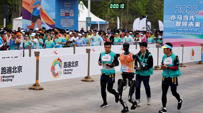 Rewrite the title up to 70 characters: China’s humanoid robots fall behind humans in historic half-marathon